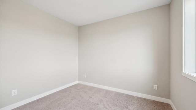 7472 170th Ave NW, Ramsey, MN 55303 - spare room featuring baseboards and carpet