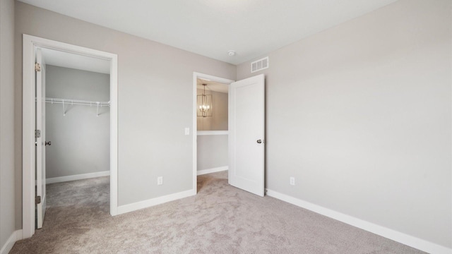 7472 170th Ave NW, Ramsey, MN 55303 - unfurnished bedroom featuring a closet, visible vents, baseboards, carpet floors, and a notable chandelier