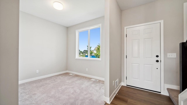 7472 170th Ave NW, Ramsey, MN 55303 - entrance foyer featuring baseboards, visible vents, and dark colored carpet