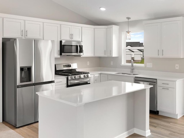 kitchen with pendant lighting, stainless steel appliances, sink, and a kitchen island