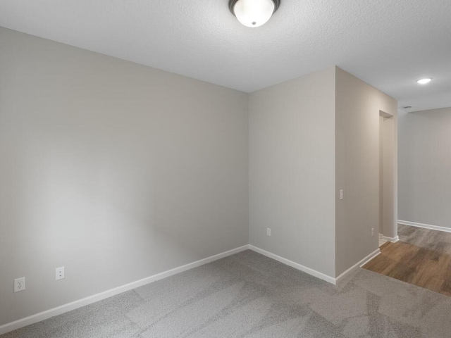 carpeted empty room with a textured ceiling