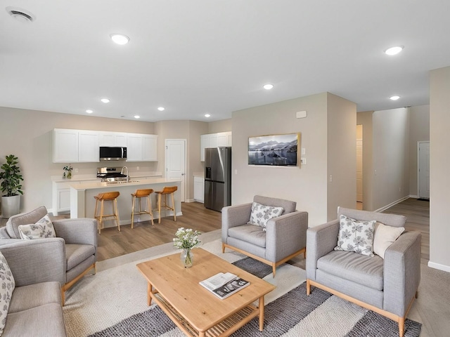 living room with sink and light hardwood / wood-style floors