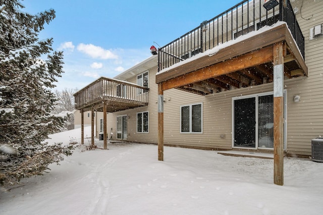 snow covered property featuring central AC and a deck