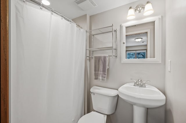 bathroom featuring curtained shower and toilet