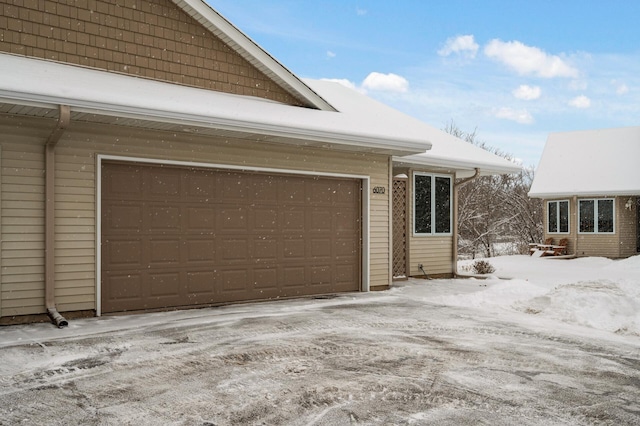 view of snow covered exterior with a garage