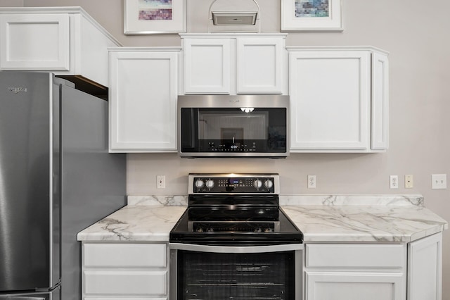 kitchen with stainless steel appliances, white cabinets, and light stone counters