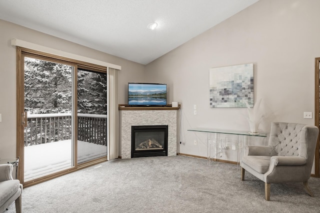 sitting room with lofted ceiling, carpet, and a textured ceiling