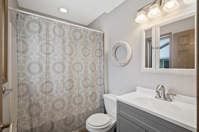 bathroom featuring walk in shower, vanity, and toilet