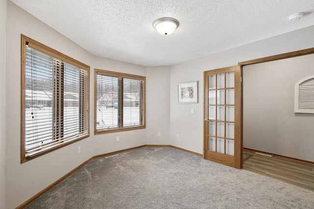 empty room featuring a textured ceiling and carpet