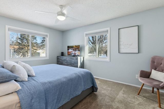 bedroom with ceiling fan, carpet flooring, multiple windows, and a textured ceiling