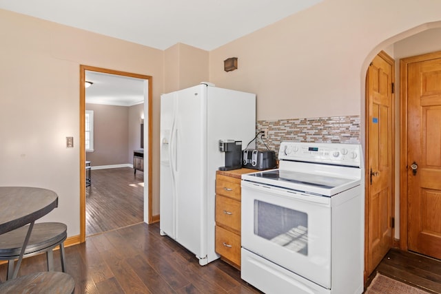 kitchen featuring dark wood-style floors, arched walkways, backsplash, white appliances, and baseboards