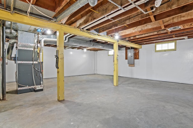 basement featuring electric panel and heating unit