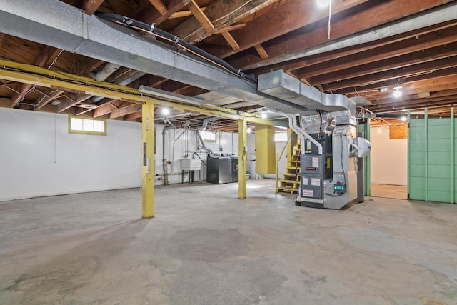 basement featuring washer / clothes dryer, a sink, and heating unit