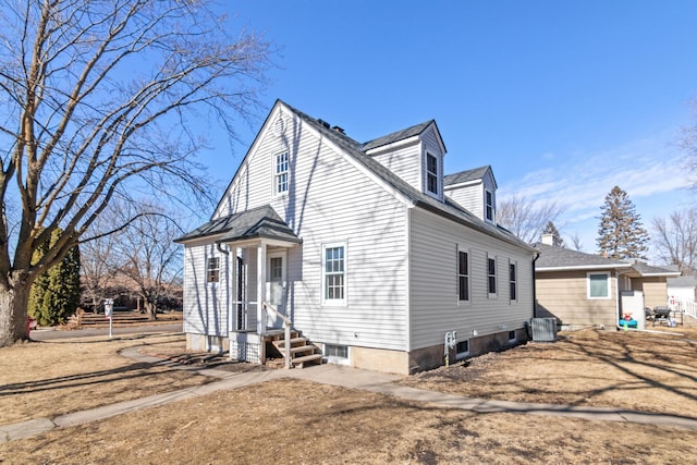 view of side of home with central AC and roof with shingles