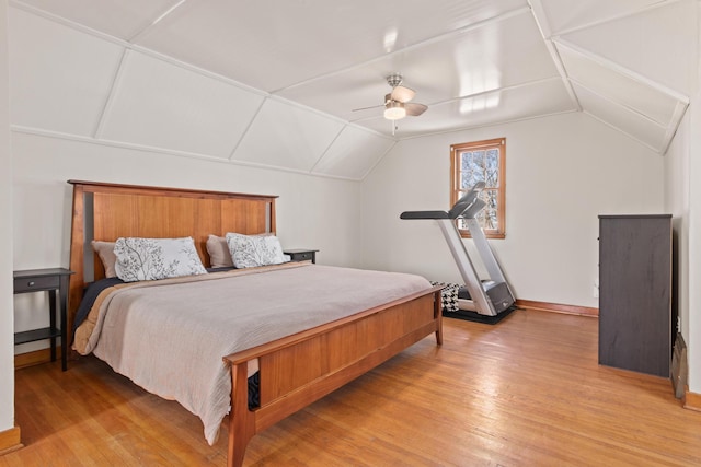 bedroom with ceiling fan, light wood-style flooring, and vaulted ceiling