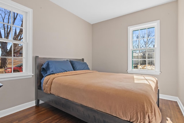 bedroom with dark wood finished floors and baseboards