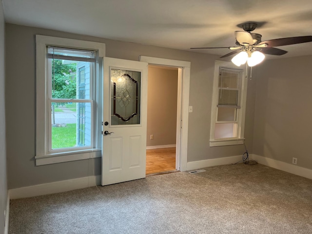 interior space with ceiling fan, carpet flooring, and a wealth of natural light