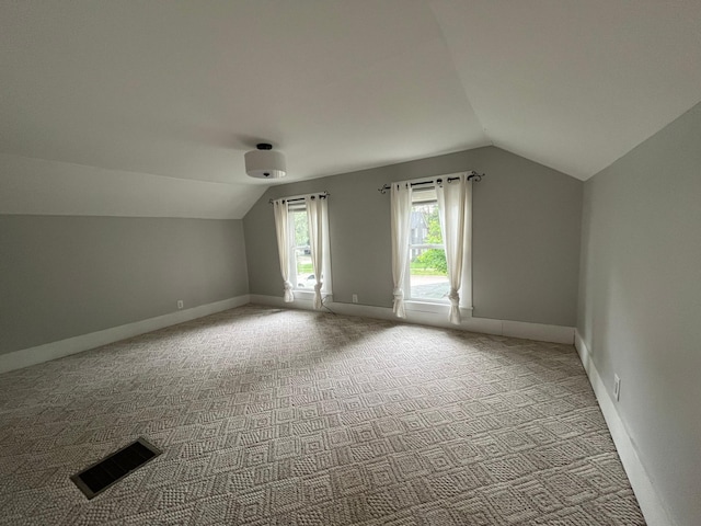 bonus room featuring lofted ceiling and light colored carpet