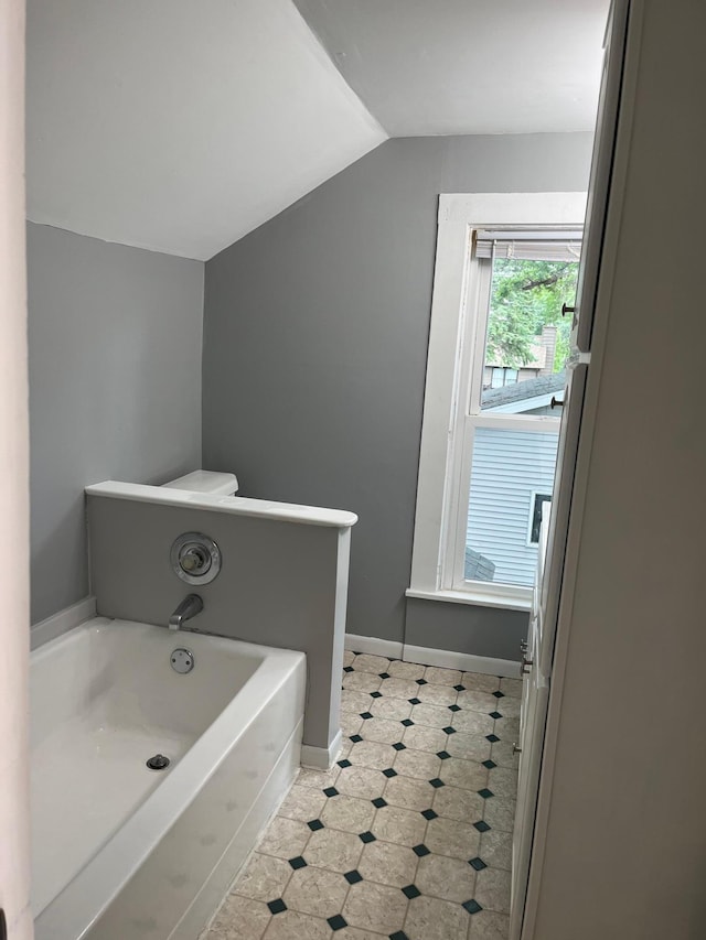 bathroom featuring lofted ceiling and a bathing tub