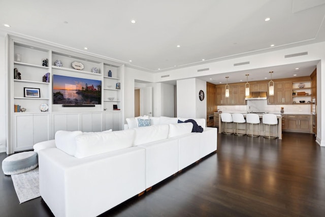 living room featuring built in features and dark hardwood / wood-style floors