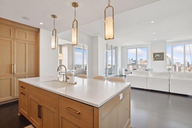 kitchen with pendant lighting, sink, an island with sink, dark hardwood / wood-style flooring, and light brown cabinets