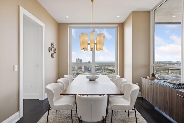 dining space with hardwood / wood-style floors and an inviting chandelier