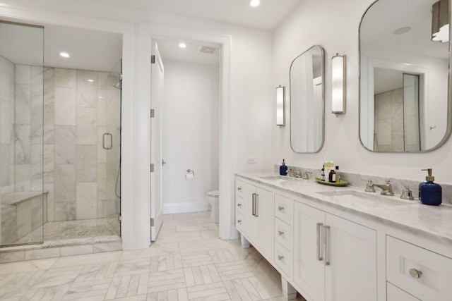 bathroom featuring vanity, toilet, and an enclosed shower