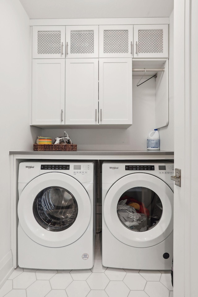 washroom with cabinets and washer and dryer