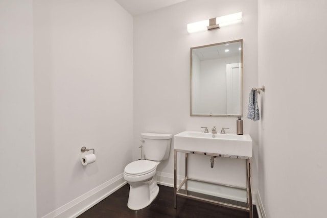 bathroom with hardwood / wood-style flooring and toilet