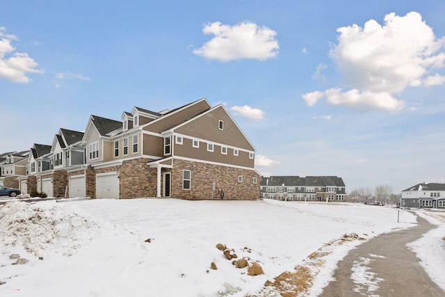 snow covered property with a garage