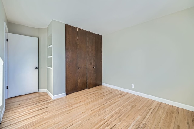 unfurnished bedroom with light hardwood / wood-style floors and a closet