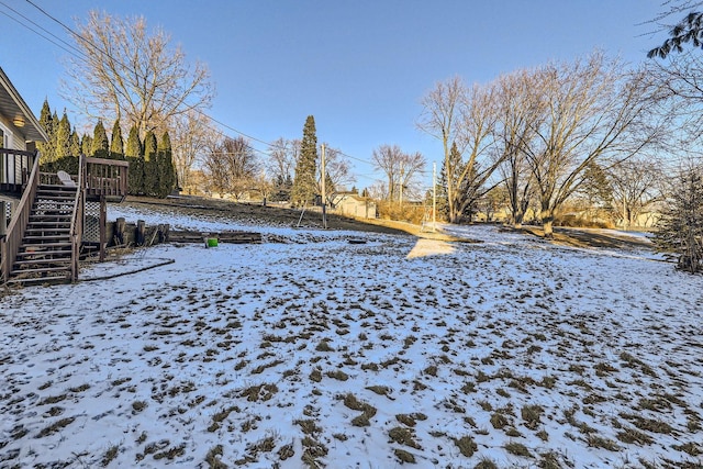 yard covered in snow featuring a deck