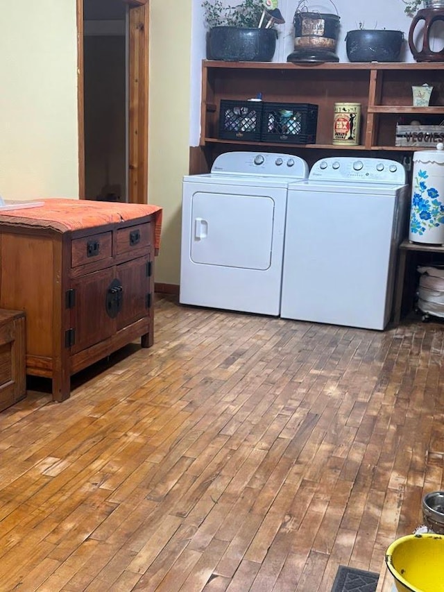 washroom featuring laundry area, wood finished floors, and washing machine and dryer