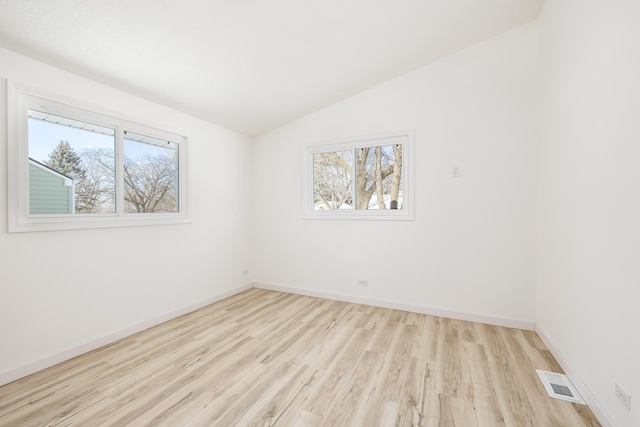 unfurnished room featuring vaulted ceiling and light wood-type flooring