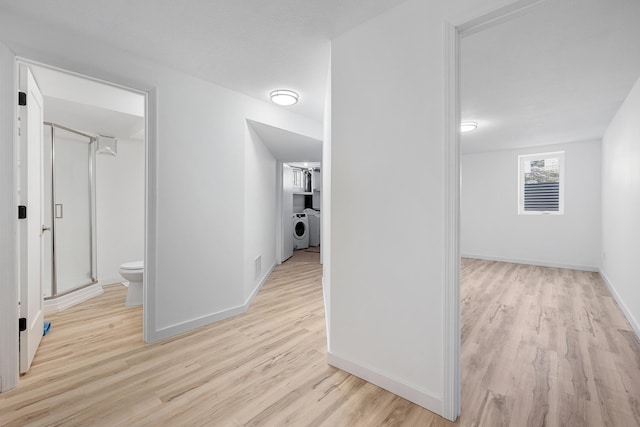 corridor featuring light hardwood / wood-style floors and washing machine and clothes dryer