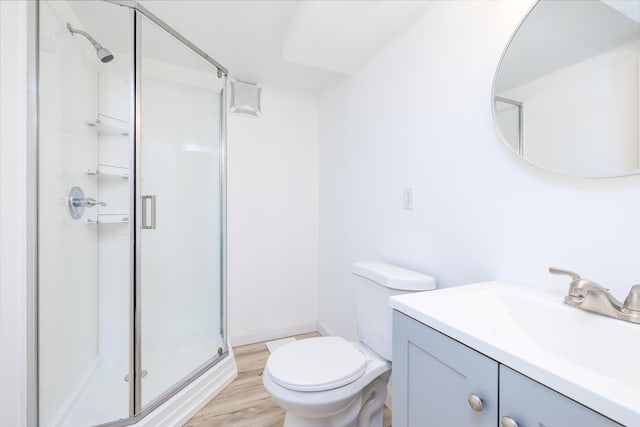 bathroom with vanity, toilet, an enclosed shower, and wood-type flooring