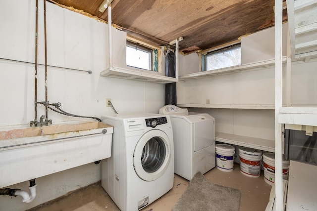 laundry area with sink, a wealth of natural light, and washer and clothes dryer