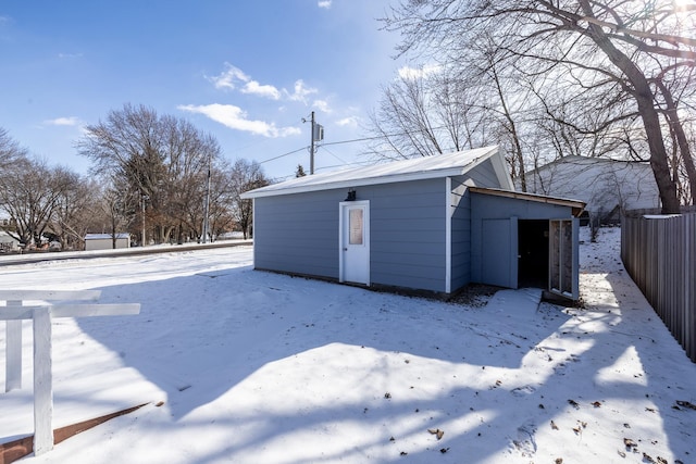 snow covered property featuring an outbuilding