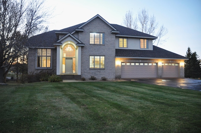 view of front of property with a garage and a lawn