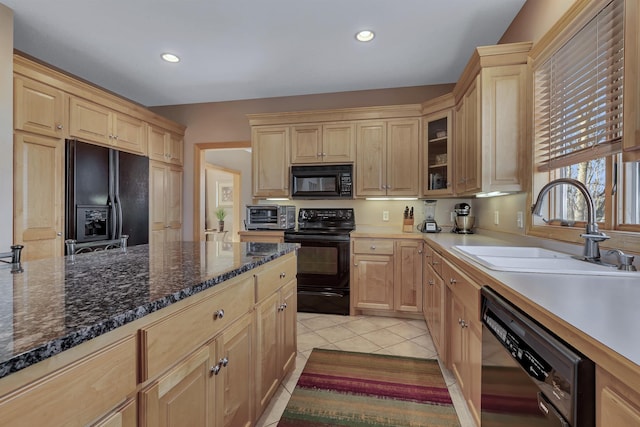 kitchen with light tile patterned flooring, light brown cabinetry, sink, and black appliances