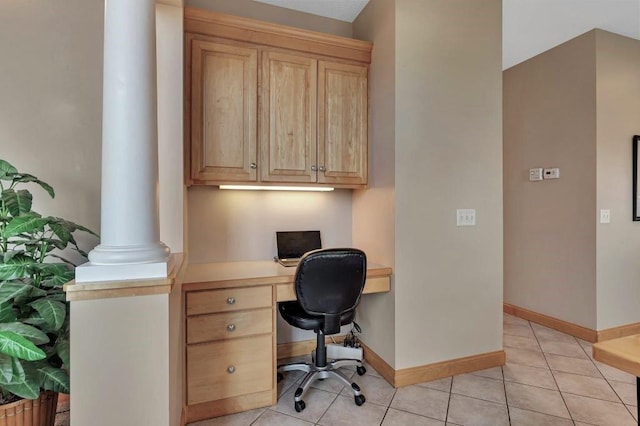 tiled home office featuring decorative columns and built in desk