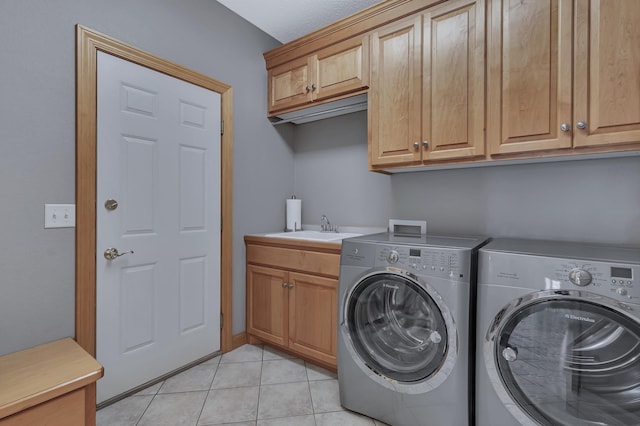 laundry room featuring washer and dryer, sink, cabinets, and light tile patterned flooring