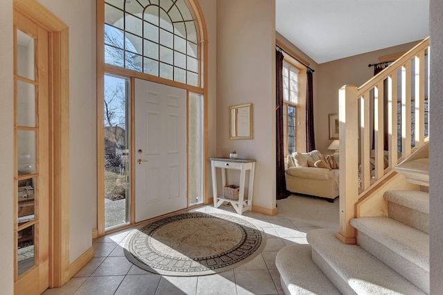 tiled foyer entrance featuring a towering ceiling