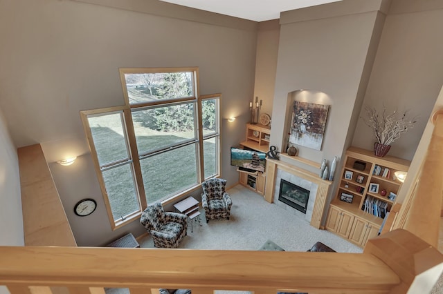 living room with carpet floors, a fireplace, and built in shelves