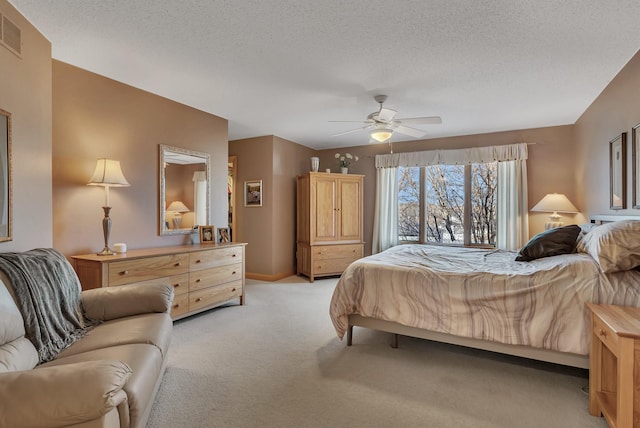 bedroom featuring ceiling fan, light carpet, and a textured ceiling