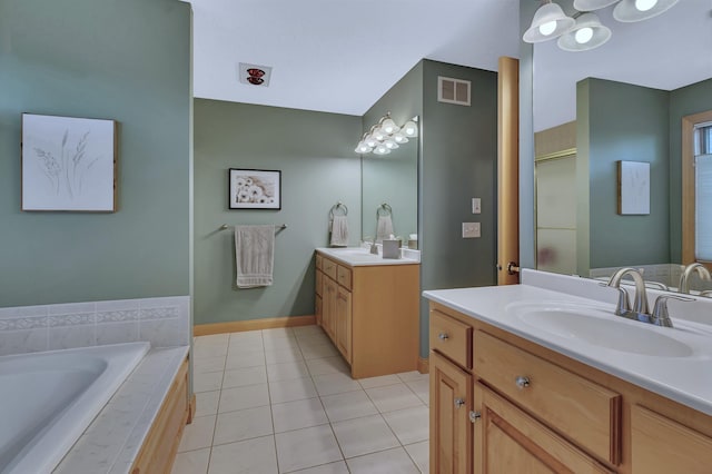 bathroom with vanity, tile patterned flooring, and a relaxing tiled tub