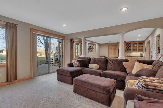 carpeted living room featuring ornate columns