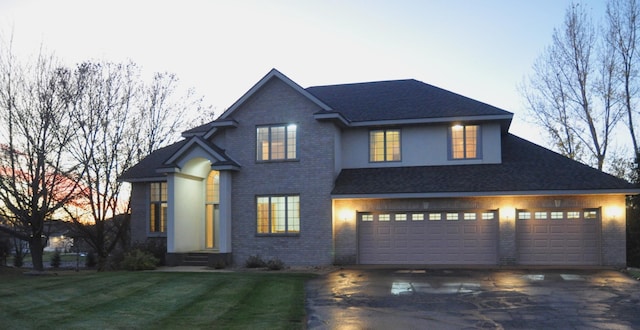 view of front of home featuring a garage and a lawn