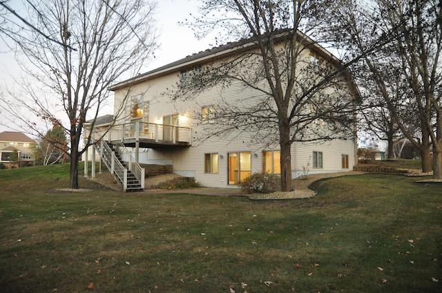 back of house featuring a lawn and a deck