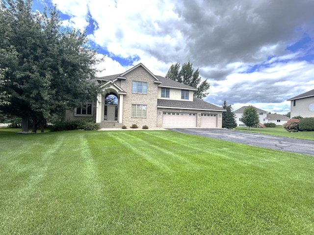 view of front of house with a garage and a front lawn